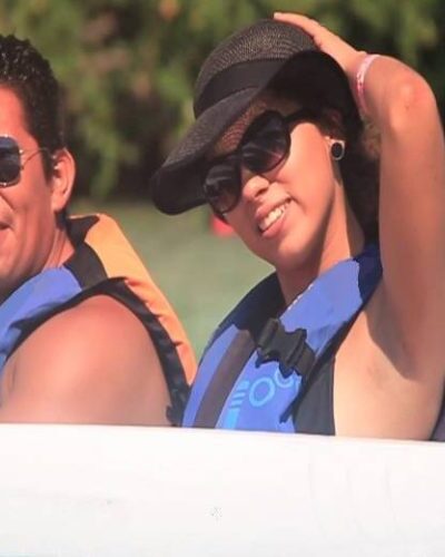 Happy couple posing on a speedboat during a jungle tour in Cancun, enjoying a fun adventure together.