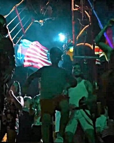 Nighttime show on the Jolly Roger pirate ship, with lights illuminating the performance against the night sky in Cancun Bay.