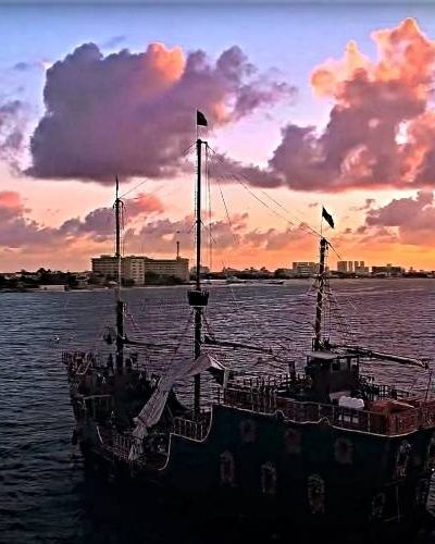 Jolly Roger pirate ship anchored in Cancun Bay at sunset, providing an atmospheric backdrop for an unforgettable evening.