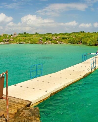 Floating bridge at Xel-Há Park, providing an adventurous crossing over crystal-clear water amidst lush surroundings.