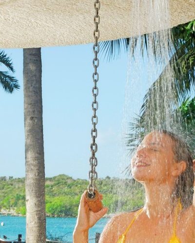 Outdoor shower area surrounded by tropical plants at Xel-Há Park, providing a refreshing experience in a natural setting in Mexico.