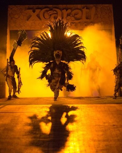 Mexican cultural performance at Xcaret Park with dancers in colorful traditional attire celebrating Mexico's heritage.