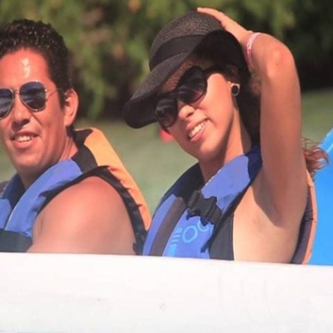 Happy couple posing on a speedboat during a jungle tour in Cancun, enjoying a fun adventure together.