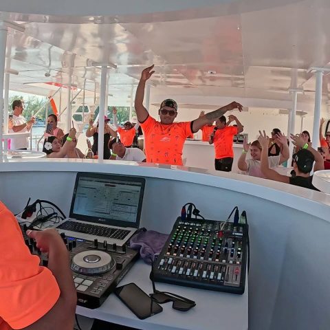 A DJ performing aboard the Baby Dancer with the Animation Team and guests dancing.