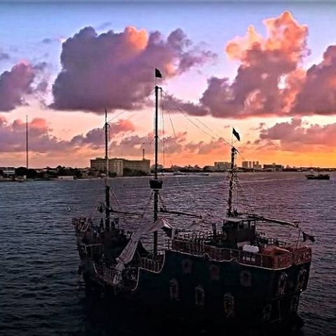 Jolly Roger pirate ship anchored in Cancun Bay at sunset, providing an atmospheric backdrop for an unforgettable evening.