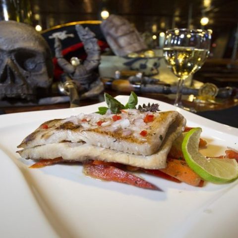 Grilled mahi-mahi with lemon and herbs, offering a fresh and delicious seafood option for guests on the Jolly Roger.