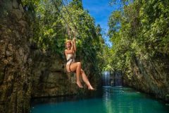 Visitor enjoying a thrilling zip line ride over lush jungle landscapes at Xplor Park in Cancun, Mexico.